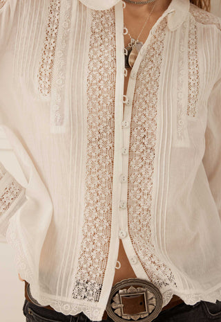  tucked into dark gray jeans with a brown belt